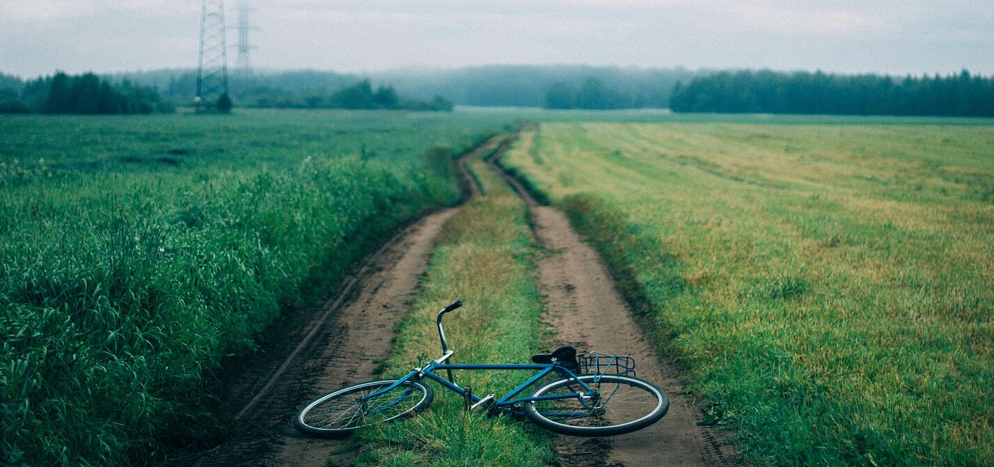Ein Fahrrad liegt auf einem Feldweg